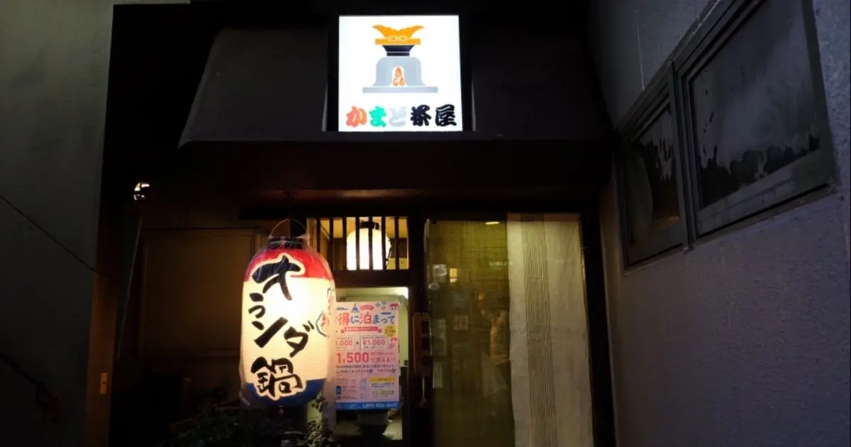 夜のかまど茶屋の入口。「オランダ鍋」と書かれた提灯と、屋号の看板